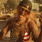A woman covered in mud wearing sunglasses, a backward cap, and a stars-and-stripes bikini top makes hand gestures and sticks out her tongue at an outdoor muddy event.