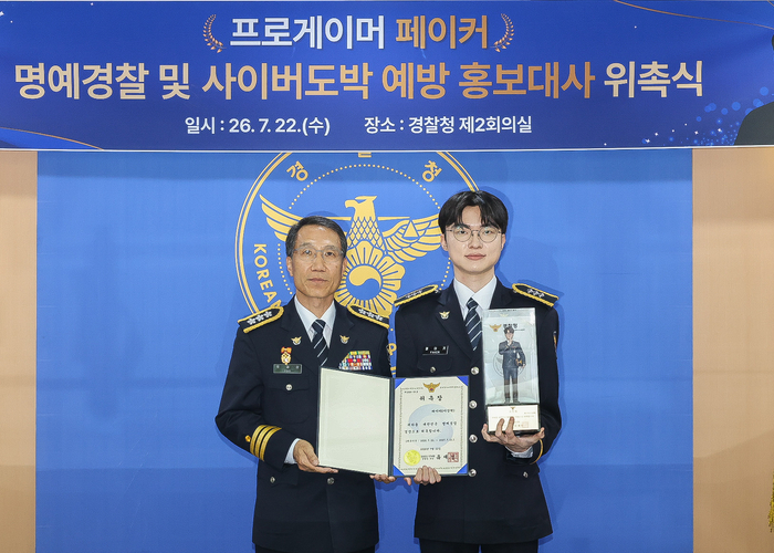 Pro gamer "Faker" Lee Sang-hyuk (right) is taking a commemorative photo with acting police chief Yoo Jae-sung after being appointed as an honorary police officer at the National Police Agency on the 22nd. [Police Agency]